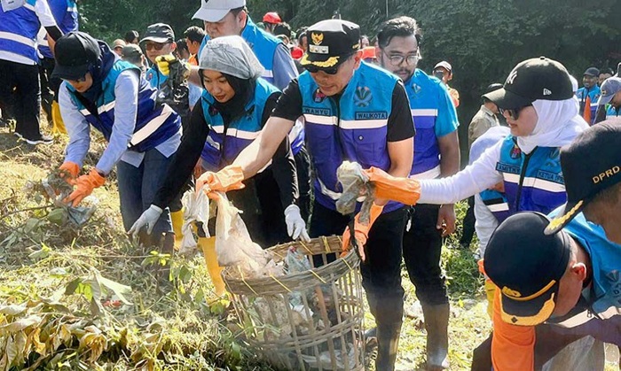 JAGA LINGKUNGAN: Wali Kota Malang Wahyu Hidayat bersama Ketua DPRD Kota Malang Amithya Ratnanggani Sirraduhita membersihkan sampah di Sungai Metro, Bandulan, Kecamatan Sukun, Kota Malang kemarin (28/9