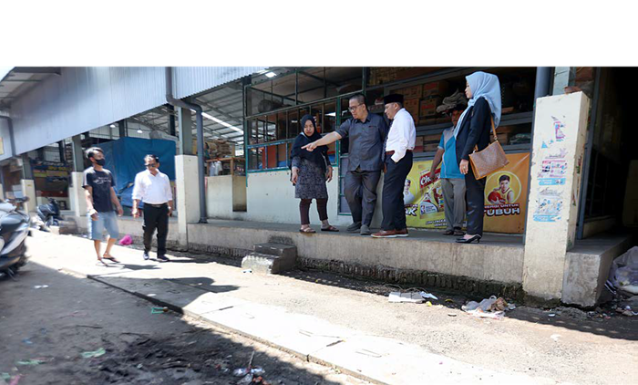 BERMASALAH: Anggota komisi DPRD Kota Malang meninjau drainase tak berfungsi di Pasar Madyopuro kemarin (2/10).