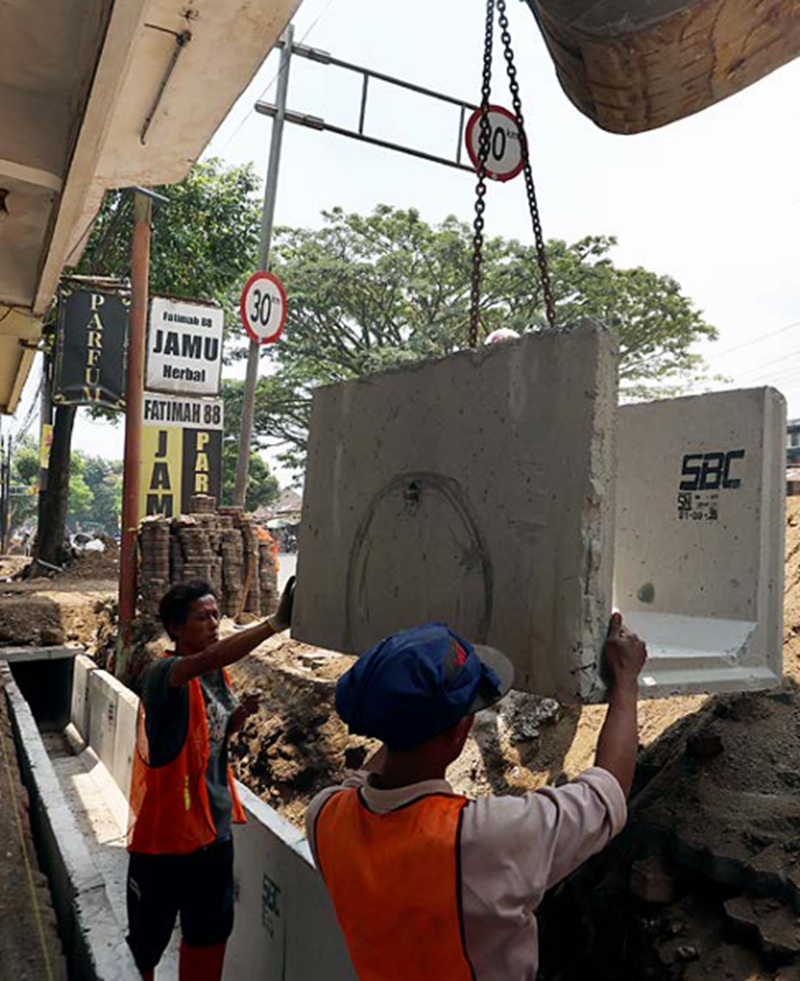 DIKEBUT: Beberapa pekerja memasang box culvert di Ciptomulyo,  Kecamatan Sukun. pemasangan menggunakan alat berat
