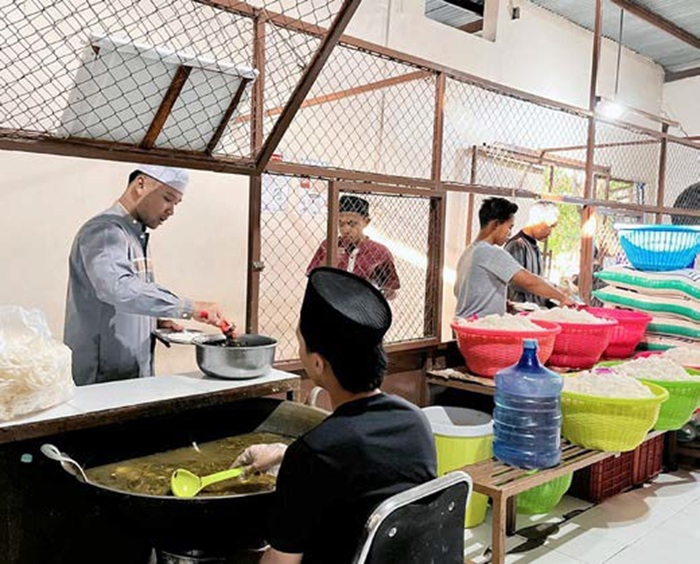 SEJAK TAHUN 2000: Santri Ponpes Bahrul Maghfiroh, di Tlogomas, Lowokwaru mengambil makanan dengan tertib kemarin.