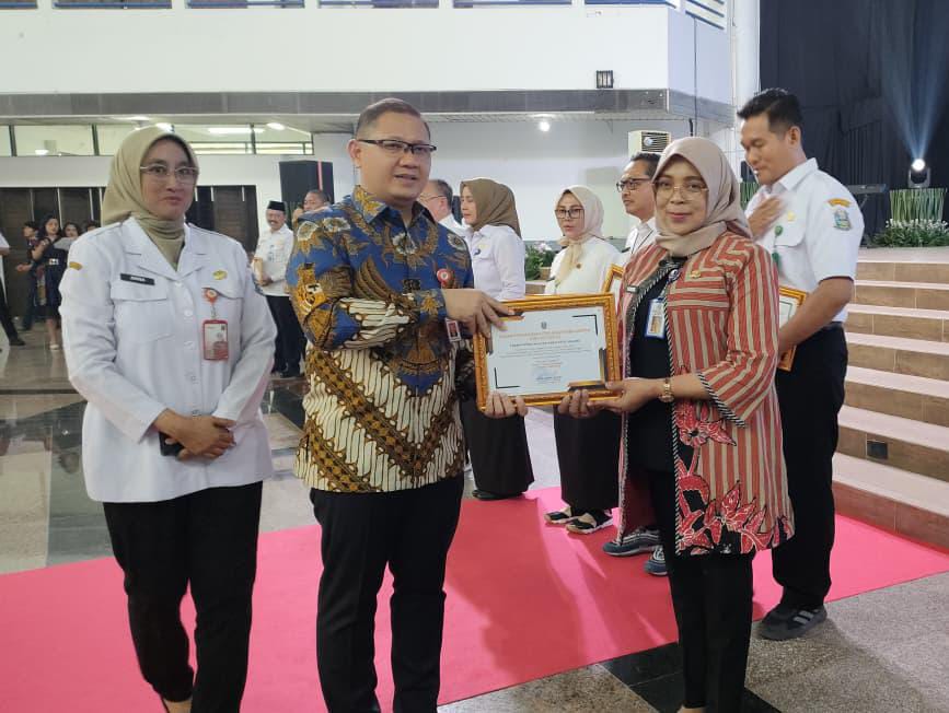 TERBAIK: Plt Cabdindik Kabupaten Malang Dr Indiyah Nurhayati MPd menerima piagam penghargaan Pencanangan Perluasan Pembangunan Zona Integritas dari Kadispenprov Jatim Dr Aries Agung Paewai SSTP.