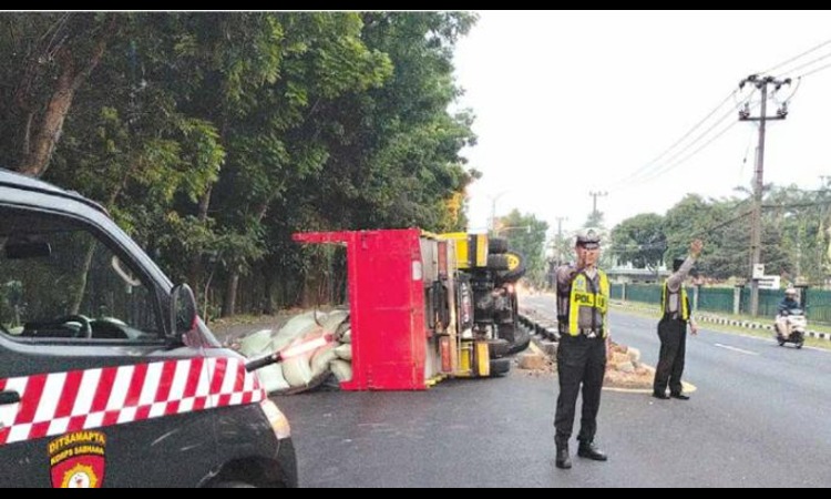 GAGAL MENYALIP: Truk bermuatan beras 10 ton terguling di Jalan Raya Songsong, Singosari kemarin pagi. Kemacetan panjang sempat terjadi sampai pukul 08.30.