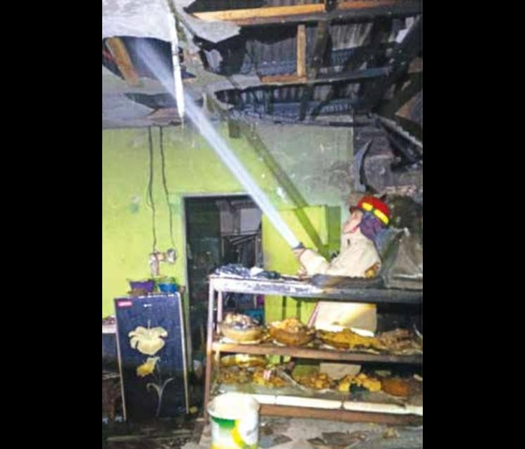DIDUGA KORSLETING: Petugas Damkar Kabupaten Malang berusaha memadamkan sisa-sisa api yang membakar warung di Desa Sukoanyar, Wajak, Kamis malam (9/10).