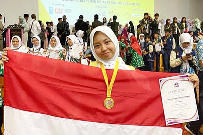 BUAH KERJA KERAS: Talita Aurelia Putri Setiawan mengibarkan bendera merah putih di sela-sela program pertukaran pelajar di Malaysia, akhir September lalu.