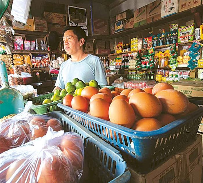 HANYA BISA PASRAH: Seorang pedagang telur di Pasar Kepanjen melayani pembeli kemarin pagi. Dalam sepekan terakhir, harga telur ayam terus merangkak naik.