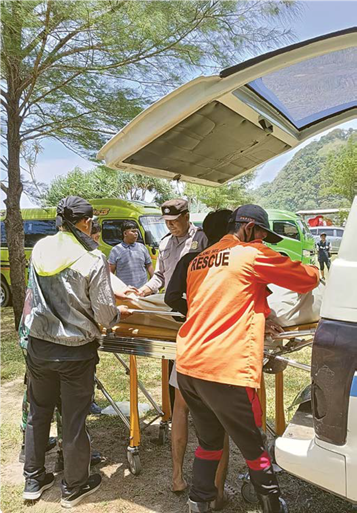MAKAN KORBAN: Petugas gabungan mengevakuasi satu wisatawan yang meninggal akibat terseret ombak Pantai Modangan kemarin.