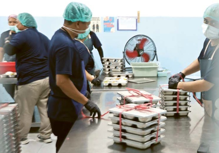 SIAP ANTAR: Petugas SPPG Buring menyiapkan makanan untuk dikirim ke sekolah kemarin siang. Pemkot Malang mendorong pengelola SPPG melengkapi perizinan mulai SLHS hingga amdal.