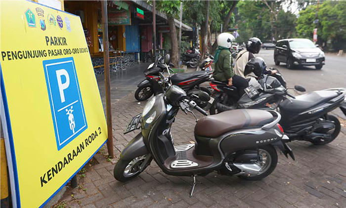 BUTUH LAHAN TAMBAHAN: Beberapa kendaraan milik pembeli di Pasar Oro-Oro Dowo parkir di tepi jalan kemarin.