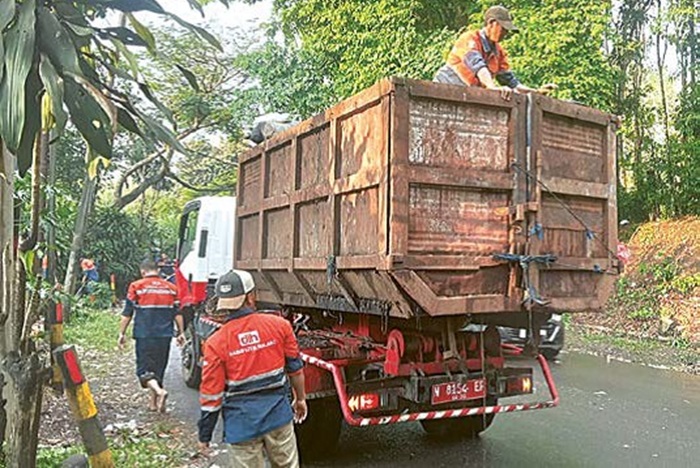 BUTUH WAKTU DUA HARI: Truk Arm Roll dikerahkan DLH Kabupaten Malang untuk mengangkut sampah-sampah yang ditinggalkan penonton Karnaval Desa Gampingan, Pagak.