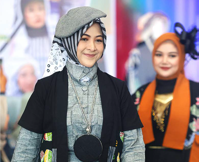 KREATIF: Ketua Pokja 3 TP PKK Kota Malang Dian Likos Amelia memperagakan busana berbahan limbah di gedung MCC kemarin (15/10).
