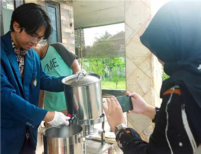 INOVATIF: Salah satu mahasiswa Universitas Brawijaya memperlihatkan proses uji coba mesin pengolah kopi susu di Dampit, Kabupaten Malang, pekan lalu.