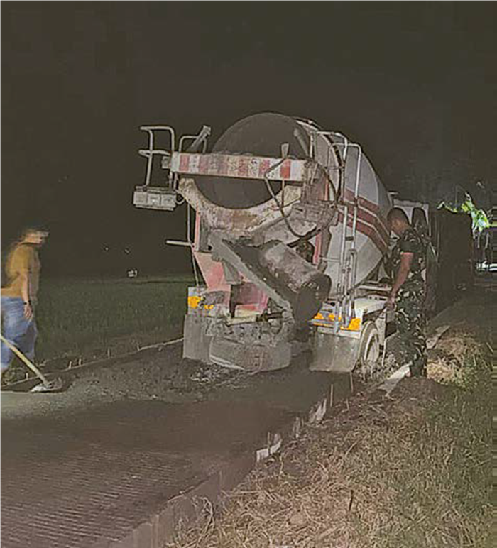 DIKERJAKAN SAMPAI MALAM: Jalan Usaha Tani (JUT) di Dusun Sukomaju B, Desa Lebakharjo, Ampelgading tengah diperbaiki anggota Kodim 0818/Malang-Batu.