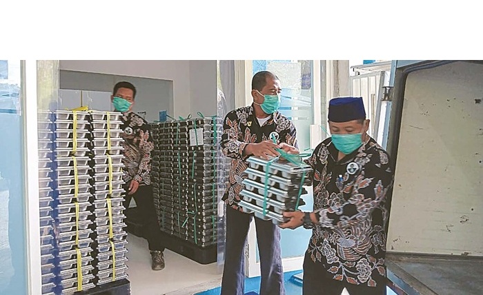 JUMLAH DITAMBAH: Petugas SPPG di Desa Kepuharjo, Kecamatan Karangploso mendistribusikan menu MBG ke sekolah pekan lalu.