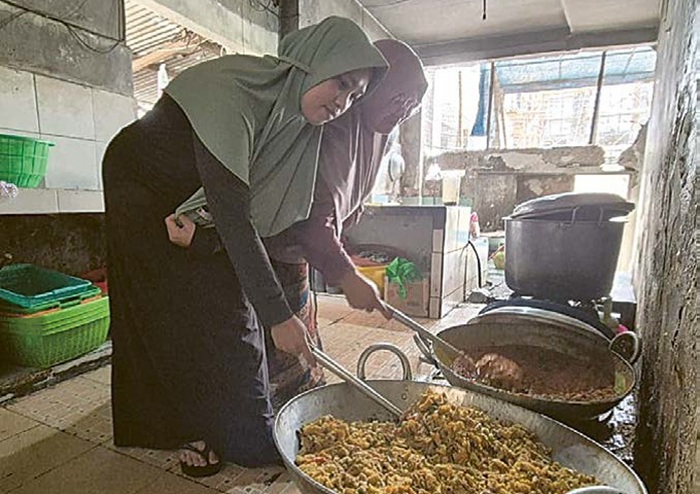 BERPENGALAMAN 14 TAHUN: Proses memasak dilakukan petugas Ponpes Darun Najah Salaf, Karangploso untuk para santrinya, kemarin.