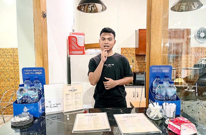 INKLUSIF: Seorang barista tunarungu di Kafe Cerita Spectra melayani pelanggan menggunakan bahasa isyarat. Pengelola kafe melibatkan tiga penyandang disabilitas dalam kegiatan operasional sehari-hari.