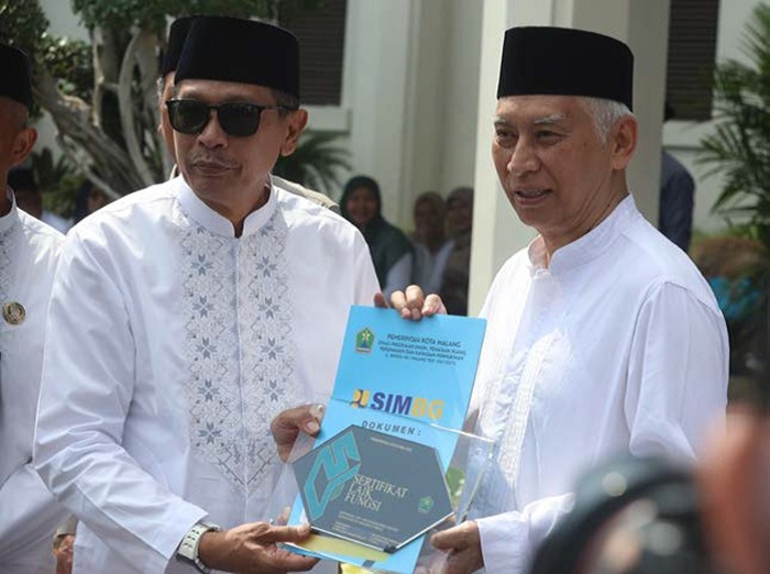 SATU-SATUNYA: Pengasuh Ponpes Bahrul Maghfiroh Prof Dr Muhammad Bisri, MS menerima Sertifikat Laik Fungsi (SLF) dari Wali Kota Malang Wahyu Hidayat (kiri) di halaman Balai Kota Malang kemarin (22/10).