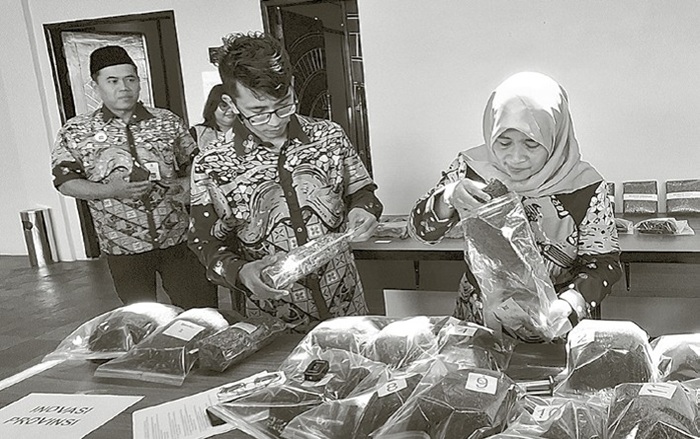 BEKAL PENGETAHUAN: Tembakau yang dibawa perwakilan petani dicek pemateri untuk melihat kadar air dan kualitasnya.