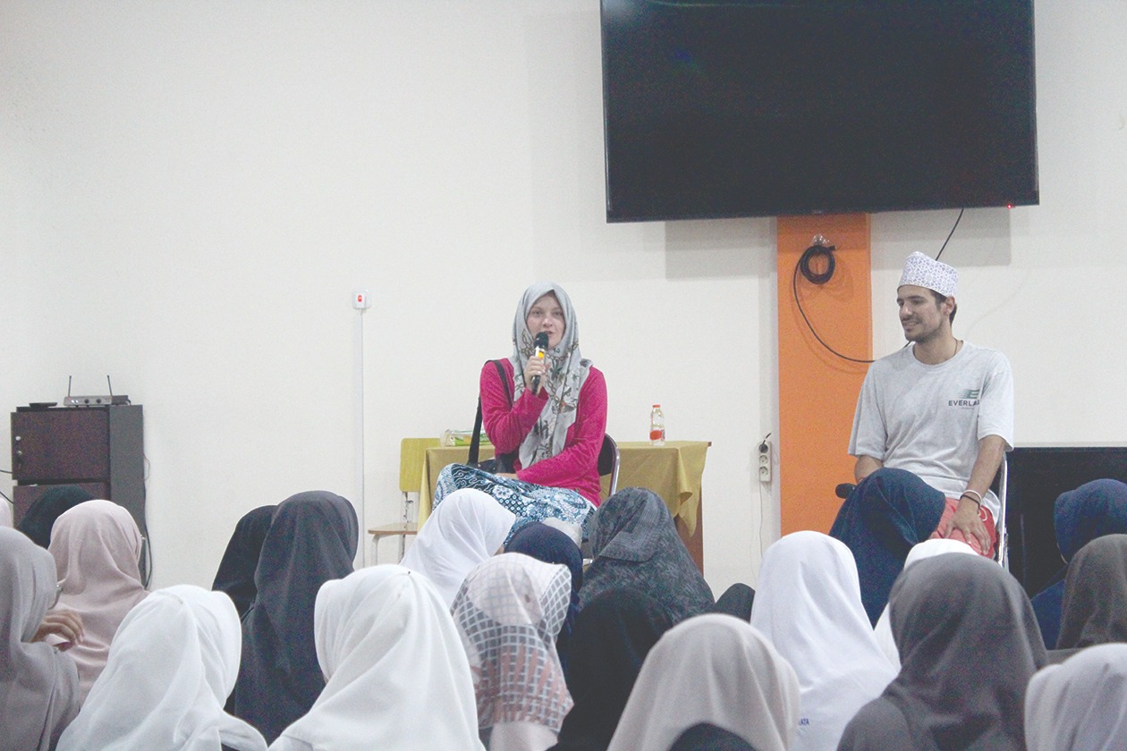 Siswi SMPIT Insan Permata (duduk di bawah) sedang mendengarkan 2 native speaker.