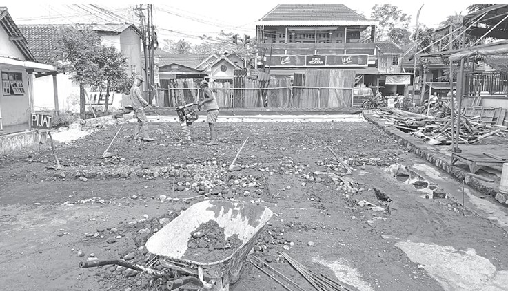 TERUS DIKEBUT: Pekerja proyek meratakan timbunan tanah di area Jembatan Krapyak, Desa Panggungrejo, Kecamatan Kepanjen, Kabupaten Malang, kemarin (26/10).