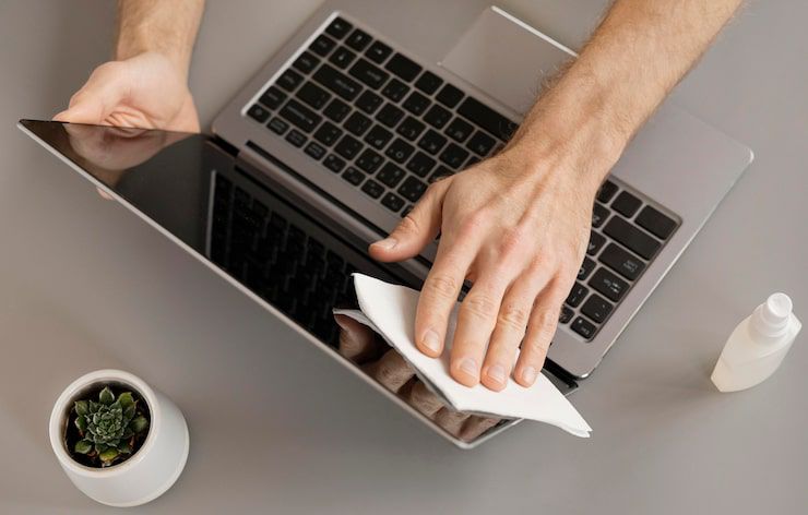 Ilustrasi merawat laptop dengan rutin membersihkannya.