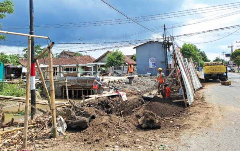 BERPROGRES: Jembatan Krapyak di Kecamatan Kepanjen masih dibangun. Cuaca yang sering hujan jadi kendala tersendiri bagi para pekerja.