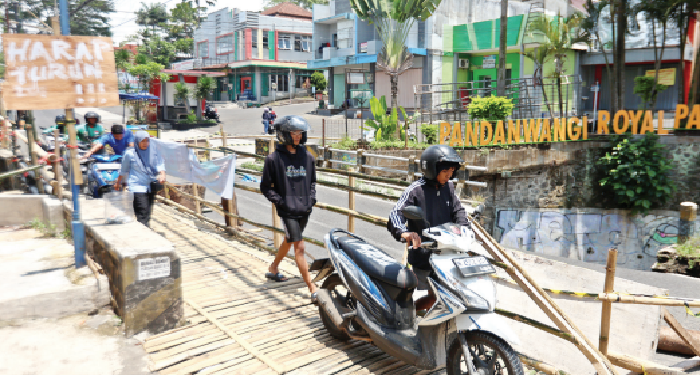 DARURAT: Pengendara sepeda motor harus menuntun kendaraannya saat melintasi jembatan bambu di Jalan Simpang Sulfat Utara kemarin (1/11)