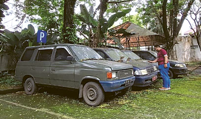 BAKAL DILELANG: Tiga mobil dinas Pemkab Malang terparkir dalam kondisi tak terurus di area sekitar Masjid Pendopo Kabupaten Malang, Kepanjen, kemarin.