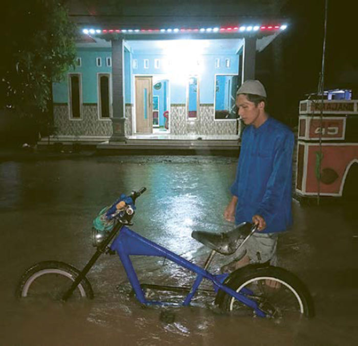HARUS MENGUNGSI: Seorang warga Desa Lebakharjo harus melewati genangan air akibat banjir yang terjadi pada Sabtu lalu (1/11).