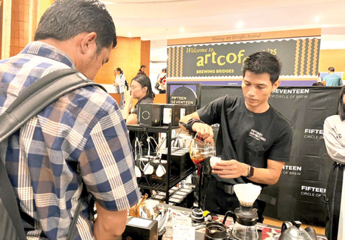 PENGGERAK EKONOMI: Seorang barista menyajikan kopi kepada pembeli dalam sebuah pameran di Universitas Brawijaya (UB) pada Senin (3/11).
