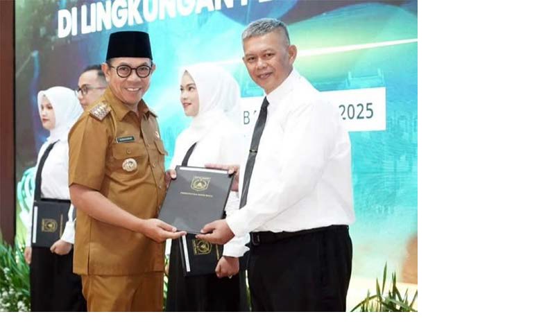 PENANTIAN PANJANG: Toton Taufan Poernomo (kanan) menerima SK pengangkatan PPPK dari Wali Kota Batu Nurochman di Gedung Graha Pancasila Balai Kota Among Tani Batu pada 19 Mei lalu.
