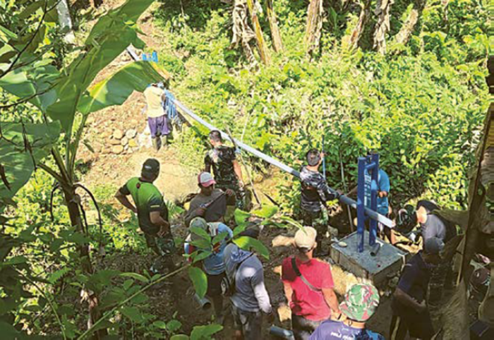 ATASI KRISIS AIR BERSIH: Personel kodim 0818 Kabupaten Malang-Batu memasang pipa di Desa Lebakharjo, Kecamatan Ampelgading beberapa waktu lalu.