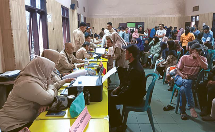 JEMPUT BOLA: Petugas Bapenda Kabupaten Malang melayani warga yang membayar pajak di Balai Desa Pujon Lor, Kecamatan Pujon.
