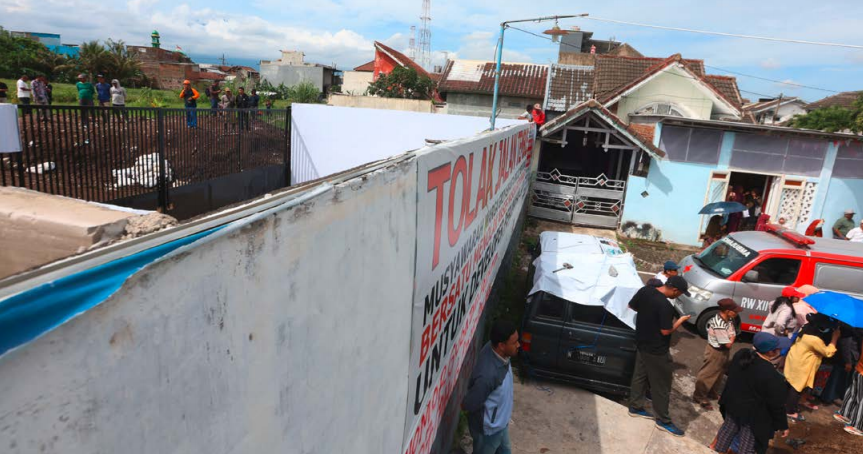 MASIH TEGAK: Tembok pembatas Perumahan Griyashanta tetap berdiri dan dijaga warga RW 12 kemarin siang. Pemkot Malang belum menentukan langkah lanjutan setelah rencana pembongkaran ditunda.