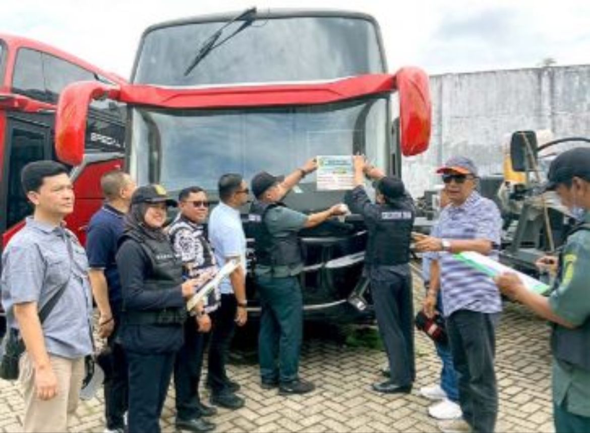 PERKARA PO ASAL SUMUT: Petugas dari Pengadilan Agama (PA) Kota Malang menempelkan sticker tanda penyitaan terhadap salah satu bus yang diproduksi Karoseri Adiputro, Kamis lalu (6/11).