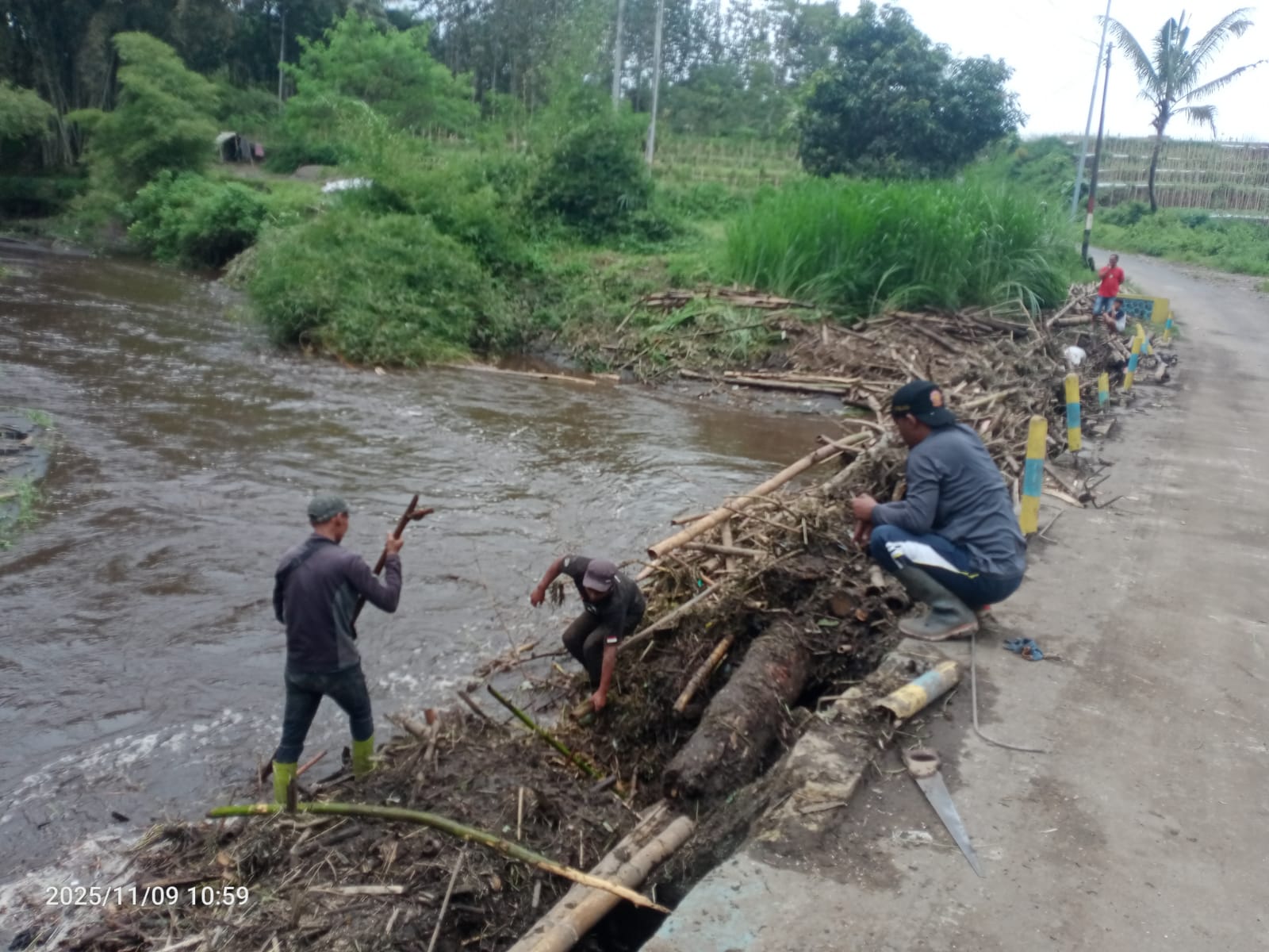 Warga Dusun Wonorejo, Desa Wringinanom membersihkan jembatan yang tertutup bambu dan sampah Minggu (9/11). (Didik Agus Mulyono for Radar Malang)