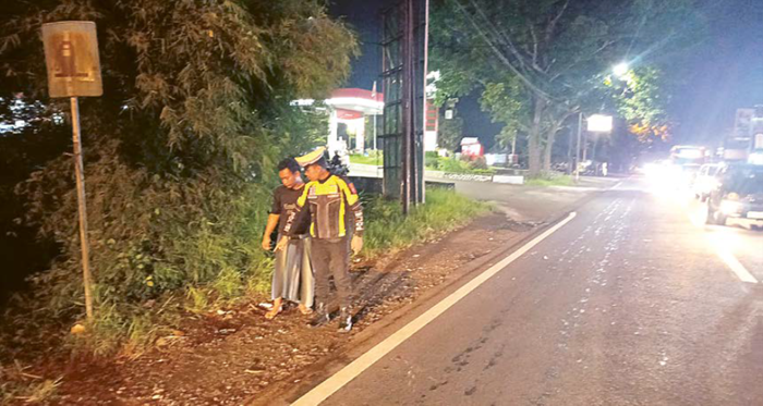 LAKA: Aparat kepolisian menunjukkan lokasi kecelakaan di Jalan Raya Genengan, Pakisaji pada Minggu malam (9/11)