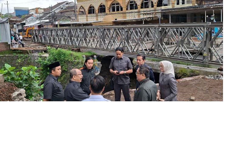 PANTAU LANGSUNG: Anggota Komisi C DPRD Kota Malang meninjau proses pemasangan jembatan bailey di Jalan Simpang Sulfat Utara, Blimbing, kemarin.