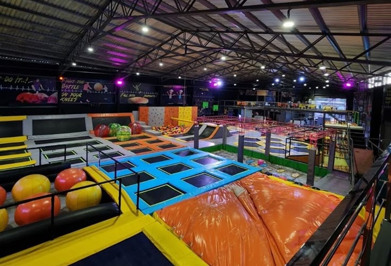 Ilustrasi tempat bermain indoor dengan berbagai permainan dan trampolin