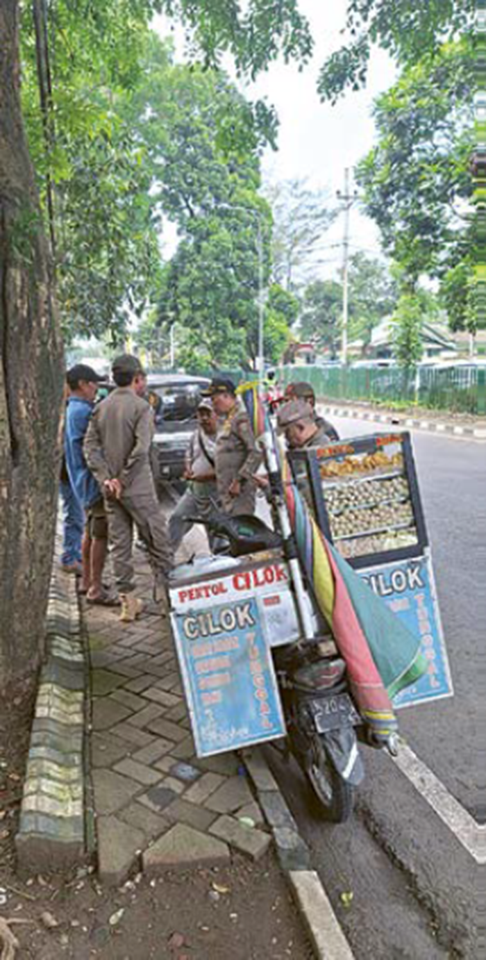 TINDAK TEGAS: Beberapa personel satpol PP Kabupaten Malang menertibkan PKL yang berjualan di tepi Jalan Panji, Senin lalu (10/11)