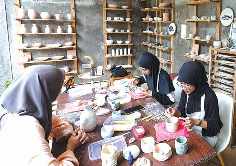 KONSENTRASI: Peserta pottery class membentuk tanah liat menjadi vas bunga. Peserta dibimbing untuk membuat produk yang bisa langsung dibawa pulang setelah proses pembakaran.