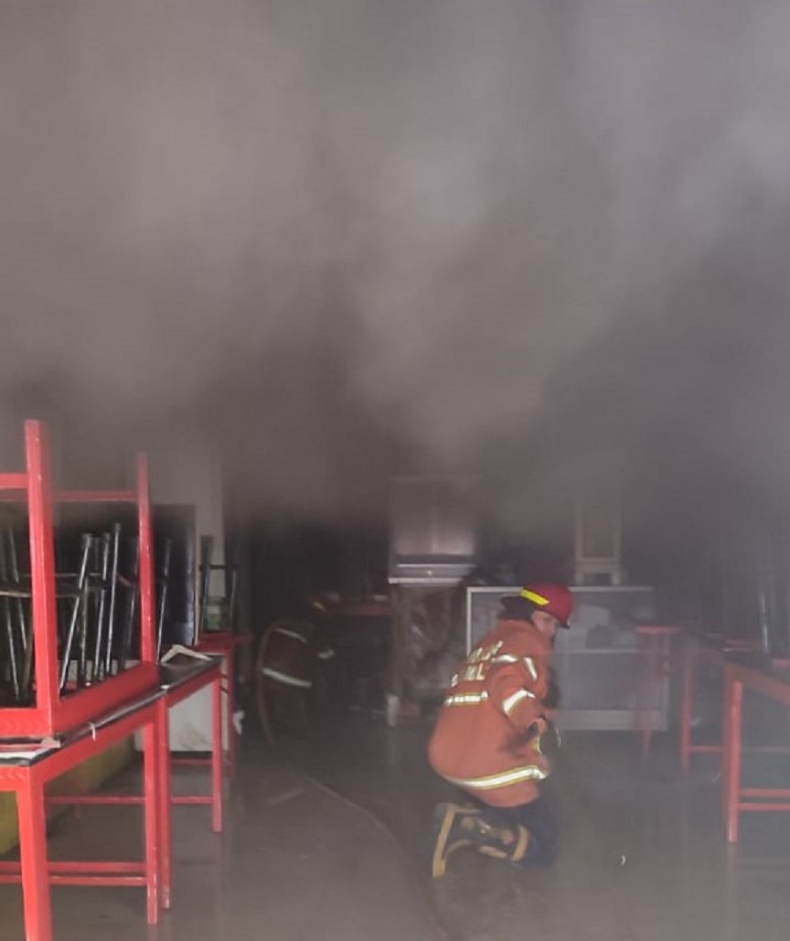 Petugas pemadam masuk ke dalam ruang dapur yang dipenuhi asap pekat saat memadamkan kebakaran di sebuah rumah makan, di Jalan IR Rais, Minggu (16/11). (UPT Damkar Kota Malang for Radar Malang)