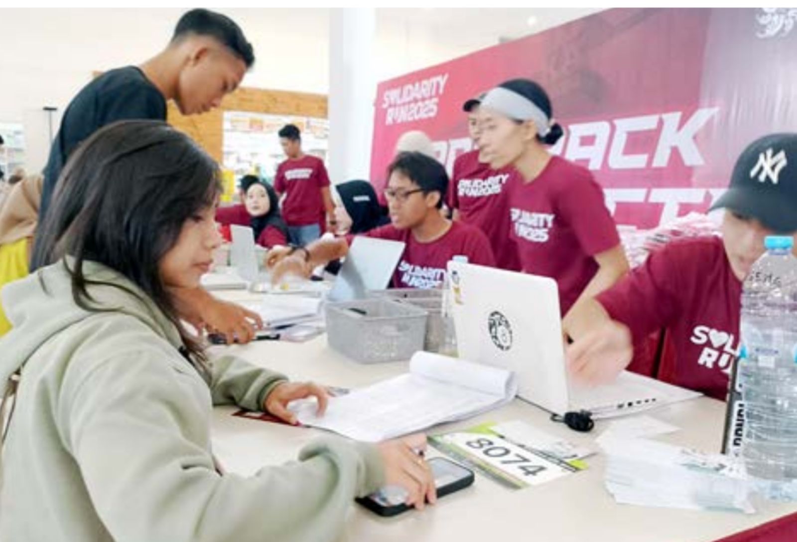 DIIKUTI 2.000 PELARI: Para peserta Solidarity Run 2025 mengambil race pack di Malang City Point (MCP), kemarin (15/11).