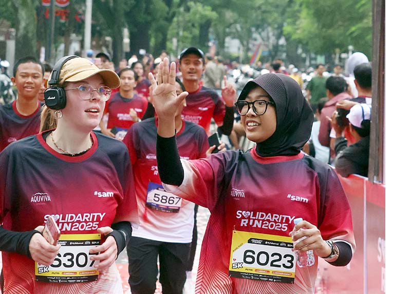 NGALAM TAHES: Runner dari mancanegara berada di garis finish setelah melintasi rute Solidarity Run 2025 di Jalan Semeru, Kecamatan Klojen, kemarin (16/11).
