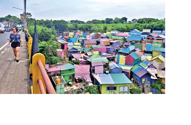 FAVORIT TURIS: Wisatawan mancanegara melintas di jembatan dekat Kampung Warna-Warni Jodipan, kemarin siang.