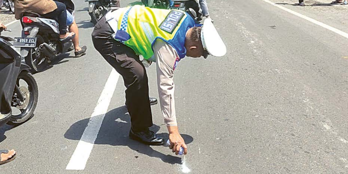 OLAH TKP: Anggota Satlantas Polres Malang menandai lokasi kecelakaan di Jalan Raya Sidomulyo, Desa Wandanpuro, Bululawang kemarin (19/11)