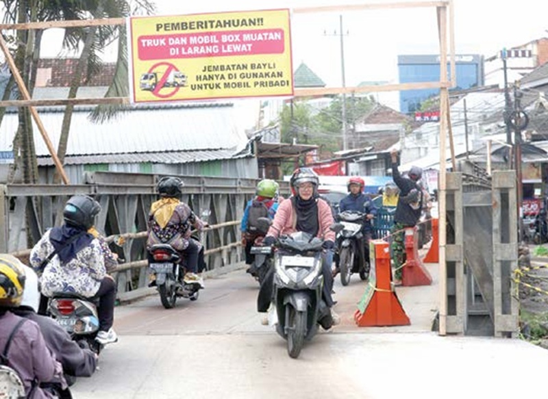 DARURAT: Kendaraan roda dua dan empat melintas di jembatan bailey  Jalan Simpang Sulfat Utara kemarin. Ke depan, truk tetap dilarang  melintas setelah pembangunan jembatan utama selesai.