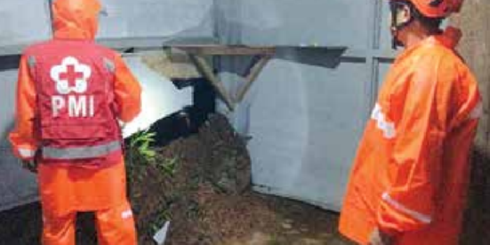 TERPAKSA MENGUNGSI: Personel memeriksa kondisi rumah rusak akibat longsoran tebing di RT 15 RW 4 Desa Pait, Kecamatan Kasembon, Kamis malam (20/11).