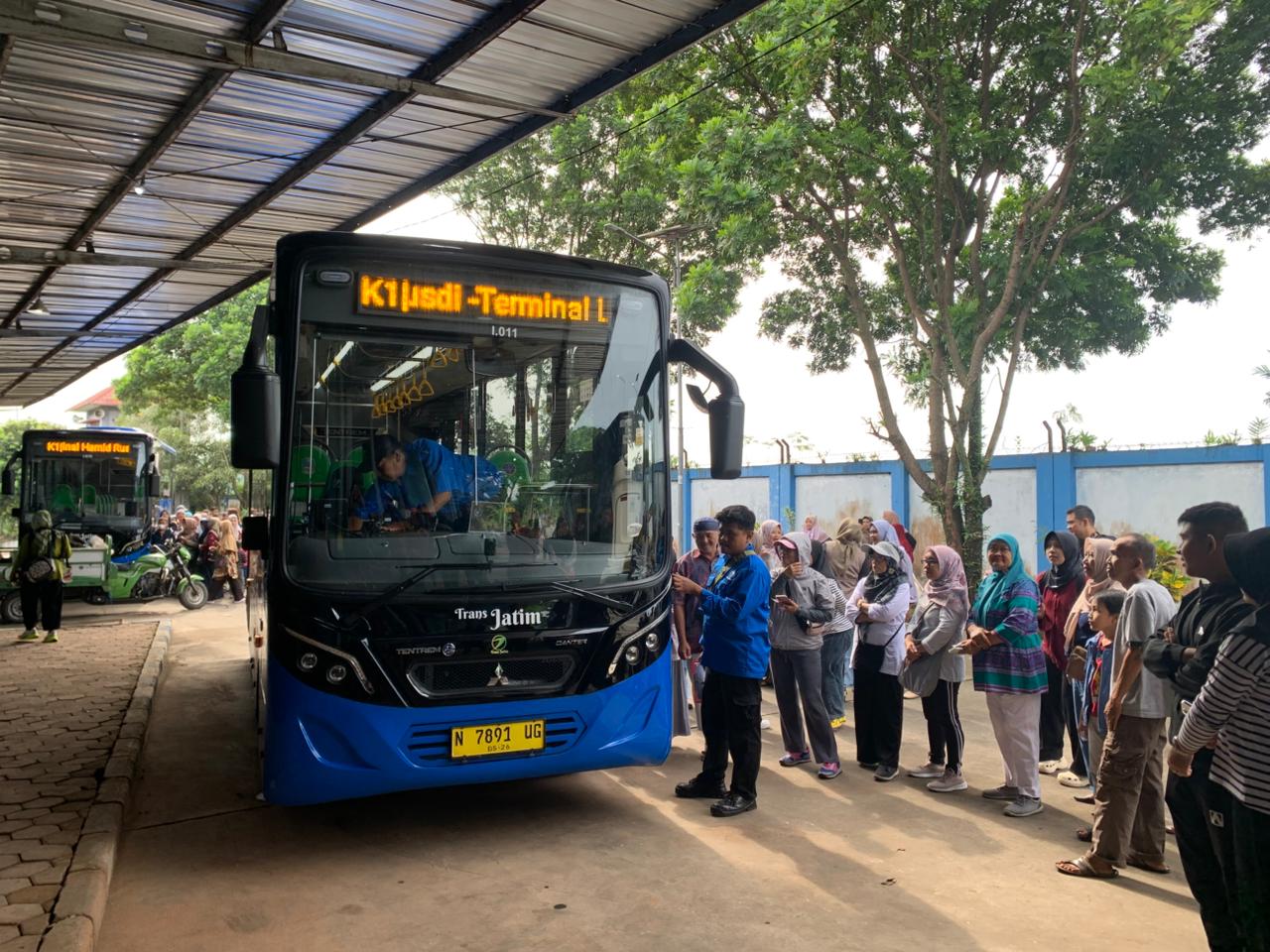 MEMBELUDAK: Warga antre untuk naik bus Trans Jatim di Terminal Hamid Rusdi kemarin pagi (23/11). (Aditya Novrian/Radar Malang)