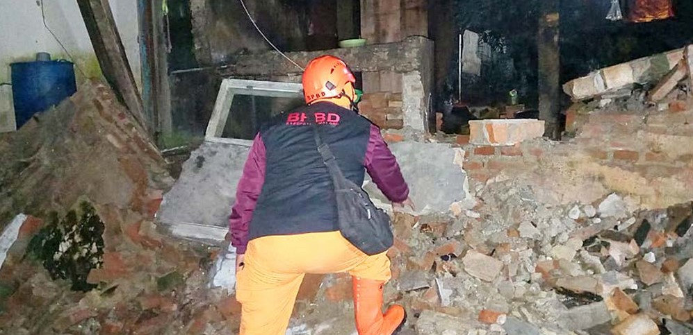 DAPAT BANTUAN: Petugas langsung mengecek salah satu rumah yang terdampak longsor di RT 5/RW 4, Desa Gubugklakah pada Jumat malam (21/11).