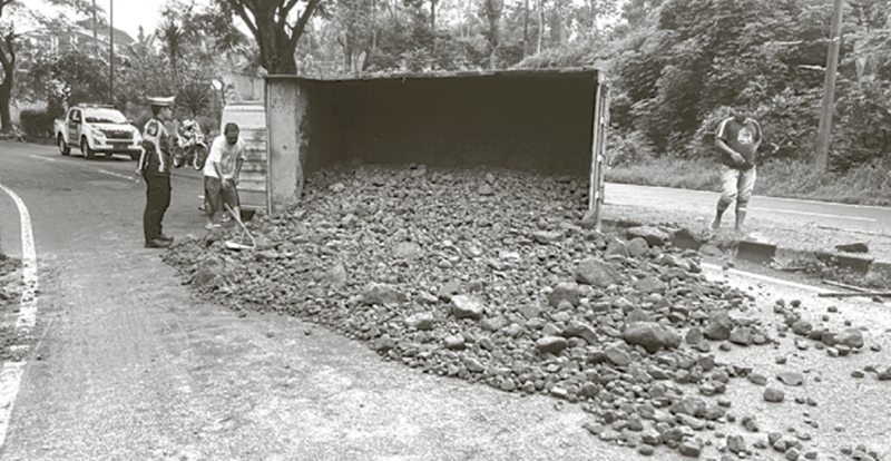 TAK KUAT NANJAK: Truk bermuatan batu terguling di tanjakan Jalibar kemarin (23/11) pagi.